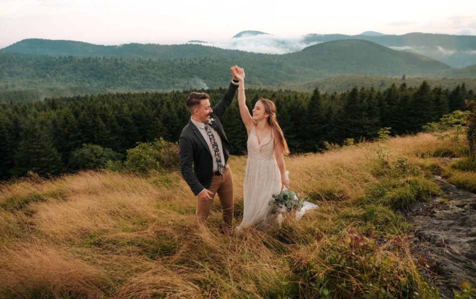 Wedding image of a couple holding hands in a forest.