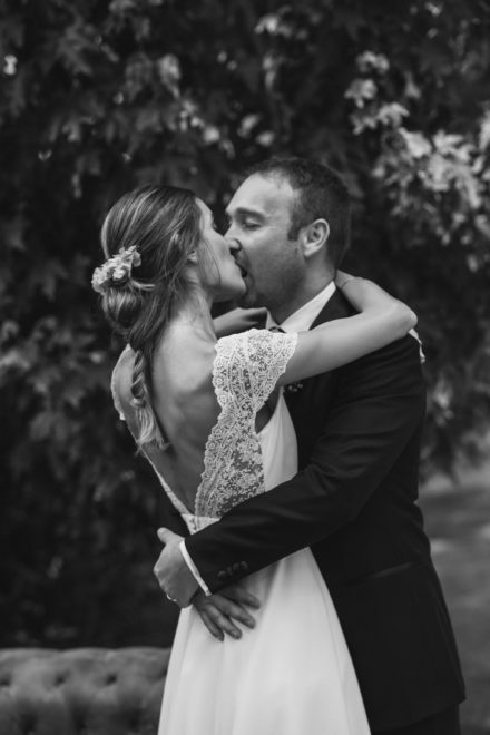 Black and white photo of the bride and groom kissing passionately