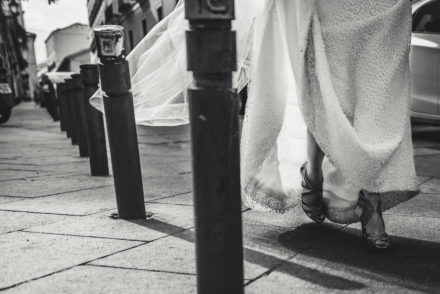Close-up photograph of the bride's legs as she walks along a cobblestone area.