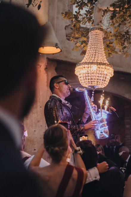Photograph of a saxophonist playing at the wedding party.