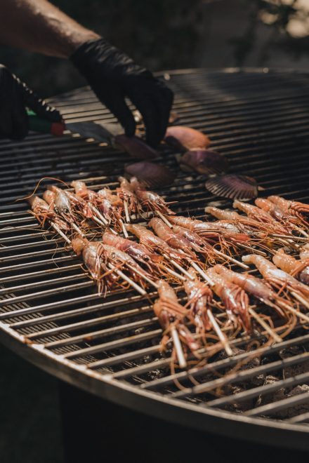 Close-up photograph of a grill with shrimp being prepared for eating.