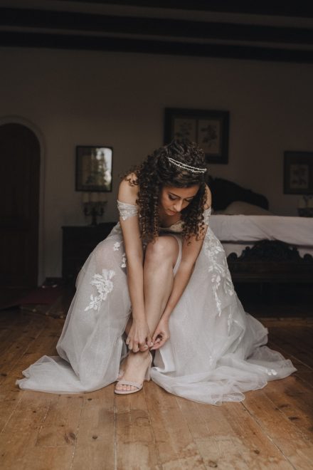 Photograph of the bride finishing putting on her heels and ready for the ceremony.