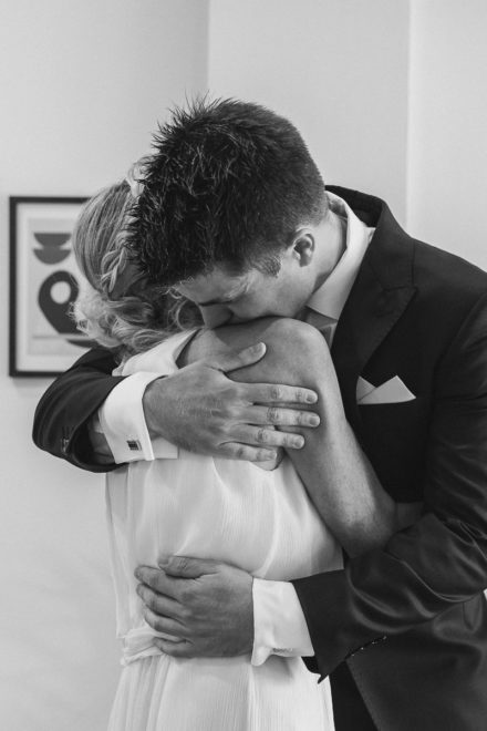 Black and white photograph of the bride and groom embracing affectionately.