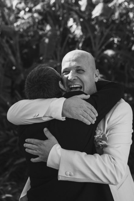 Photograph of two men happily embracing