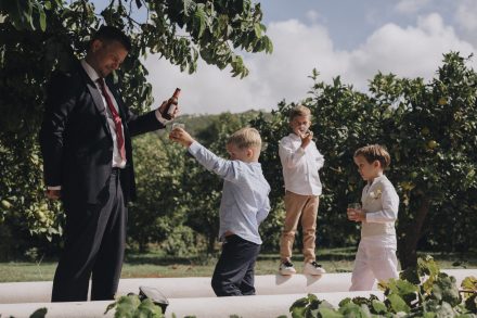 Photograph of a man taking care of three children during the wedding.