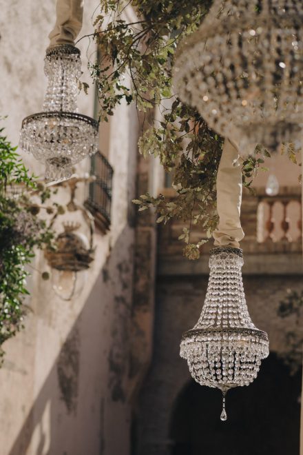 Photograph of several hanging crystal chandeliers hanging from a lamppost in the church parish.