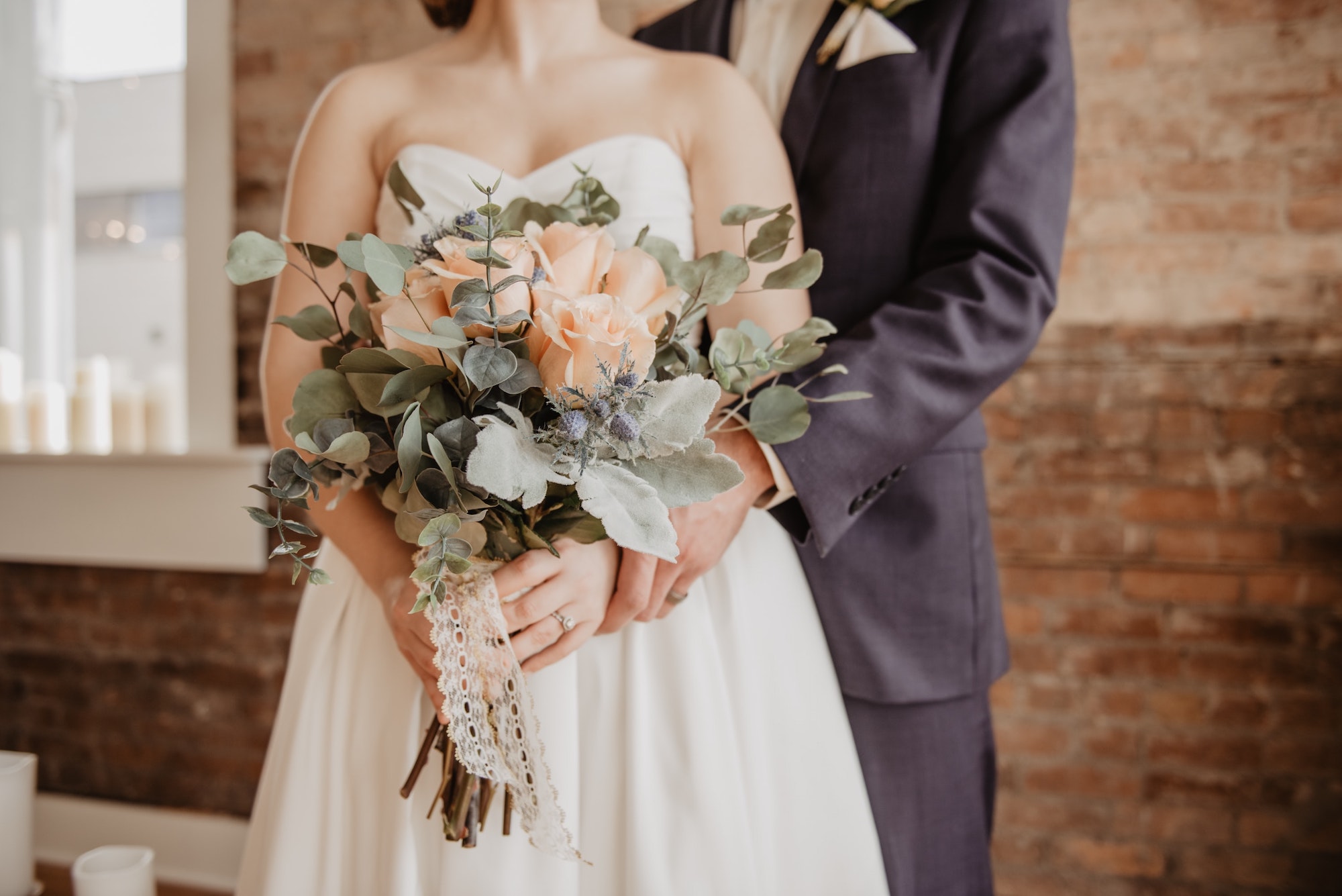 Photo of an embracing couple holding a bouquet of flowers.