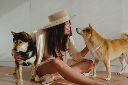 Photograph of Marta sitting on the floor with her two dogs.